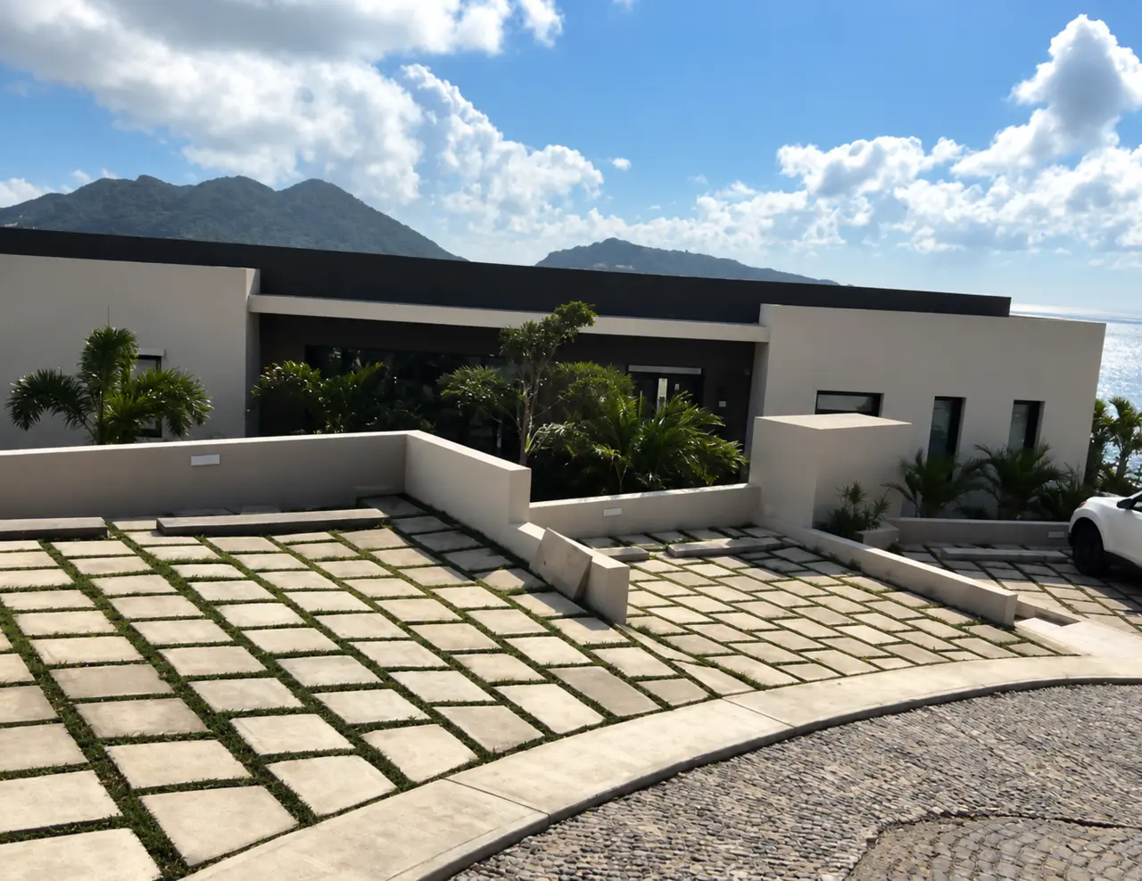 Clean architectural lines, a paved courtyard and a hillside setting.