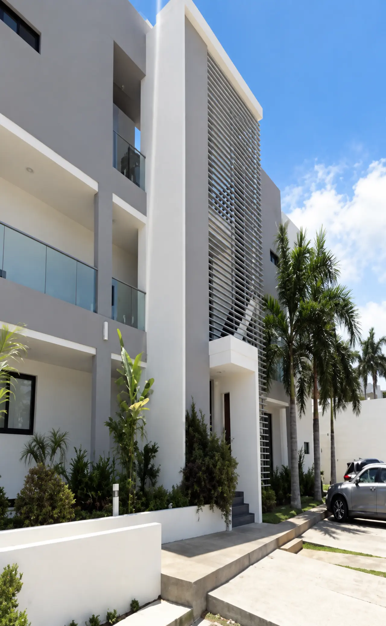 Contemporary property with pale walls, dark architectural panels and palm trees